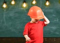 Boy play as builder or architect. Child dreaming about future career in architecture or building. Kid boy in orange hard