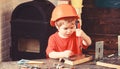 Boy play as builder or repairer, work with tools. Kid boy in orange hard hat or helmet, study room background. Child Royalty Free Stock Photo