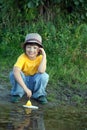 Boy play with autumn leaf ship in water, chidren in park play wi