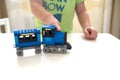 Boy play with constructor train made with colored bricks close up portrait