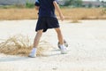 Boy play football on the dry soil ground Royalty Free Stock Photo