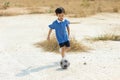 Boy play football on the dry soil ground Royalty Free Stock Photo