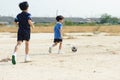 Boy play football on the dry soil ground Royalty Free Stock Photo