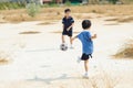 Boy play football on the dry soil ground Royalty Free Stock Photo