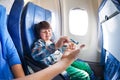 Boy play with mother in jet plane seat Royalty Free Stock Photo