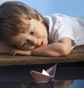 Boy play in paper ship in water puddle Royalty Free Stock Photo