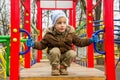 Boy on playground in cold autumn