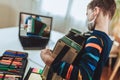 Boy playing accordion guitar and watching online course on laptop while practicing at home. Online training, online Royalty Free Stock Photo