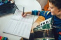 Boy playing accordion and watching online course on laptop while practicing at home. Online training, online classes Royalty Free Stock Photo