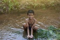 A boy playing alone in a stream in the countryside. Royalty Free Stock Photo