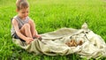 A boy is playing with animals. Kid is playing with ducklings.