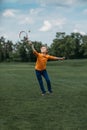 Boy playing badminton with racquet and shuttlecock, on green field Royalty Free Stock Photo