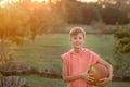 Boy playing basketball. Child holding a tball in his hands on a sunset summer day Royalty Free Stock Photo