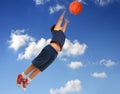 Boy playing basketball. Flying with blue sky Royalty Free Stock Photo