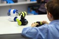 Boy playing battle fighting robots with remote control. Robotics