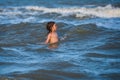 Boy playing on the beach on summer holidays. Travel lifestyle, swimming on sea summer camp. Kid jumping in the waves at Royalty Free Stock Photo