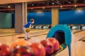 Boy playing bowling with medical masks during COVID-19 coronavirus in bowling club Royalty Free Stock Photo