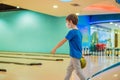 Boy playing bowling with medical masks during COVID-19 coronavirus in bowling club Royalty Free Stock Photo