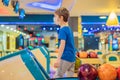Boy playing bowling with medical masks during COVID-19 coronavirus in bowling club Royalty Free Stock Photo