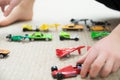 Boy playing with car collection on carpet.Child hand play. Transportation, airplane, plane and helicopter toys for children