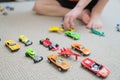 Boy playing with car collection on carpet.Child hand play. Transportation, airplane, plane and helicopter toys for children