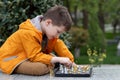 Boy playing chess outdoor. Learning strategic game. Education Royalty Free Stock Photo