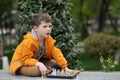Boy playing chess outdoor. Learning strategic game. Education Royalty Free Stock Photo