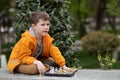 Boy playing chess outdoor. Learning strategic game. Education Royalty Free Stock Photo