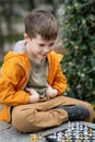 Boy playing chess outdoor. Learning strategic game. Education Royalty Free Stock Photo