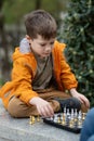 Boy playing chess outdoor. Learning strategic game. Education Royalty Free Stock Photo