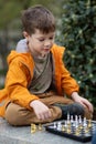 Boy playing chess outdoor. Learning strategic game. Education Royalty Free Stock Photo