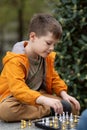 Boy playing chess outdoor. Learning strategic game. Education Royalty Free Stock Photo