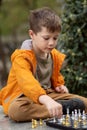 Boy playing chess outdoor. Learning strategic game. Education Royalty Free Stock Photo