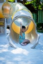 Boy playing on children`s slides. Child Playing slider at outdoor summer playground. Child playing slider on sand ground. Kid sitt Royalty Free Stock Photo