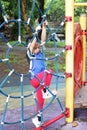 Boy is playing climb net toy alone in public playground in park on blur playground background in the power of youth condept