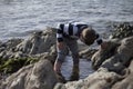 Boy Playing and Exploring in Tidal Pools Near the Ocean Royalty Free Stock Photo