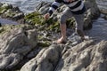 Boy Playing and Exploring in Tidal Pools Near the Ocean Royalty Free Stock Photo