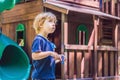 Boy playing with fidget spinner. Child spinning spinner on the playground. Blurred background