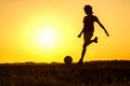 Boy playing football, teen exercising in nature at sunset Royalty Free Stock Photo