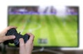 Boy playing football on television screen with game console Royalty Free Stock Photo