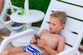 Boy playing games on the telephone. Gadget dependency disorder problem for kids during holiday vacation at the seaside