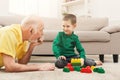 Boy playing with grandfather in building kit Royalty Free Stock Photo