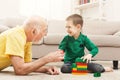 Boy playing with grandfather in building kit Royalty Free Stock Photo