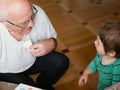 A boy is playing with grandfather. Grandfather and grandson are having fun. played a handmade board game with grandfather Royalty Free Stock Photo