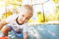 Boy playing, jumping on a trampoline, looking at camera smiling Royalty Free Stock Photo