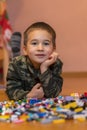 boy playing with lots of colorful plastic blocks constructor sitting on a floor indoor Royalty Free Stock Photo