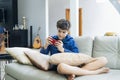 The boy playing online game on smartphone at home Royalty Free Stock Photo