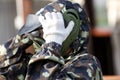 Boy is playing paintball on the field. two teams of paintball players in camouflage form with masks, helmets, guns on the field