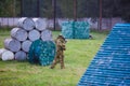 Boy is playing paintball on the field. two teams of paintball players in camouflage form with masks, helmets, guns on the field Royalty Free Stock Photo