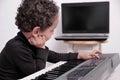 Boy playing the piano keyboard stock photo